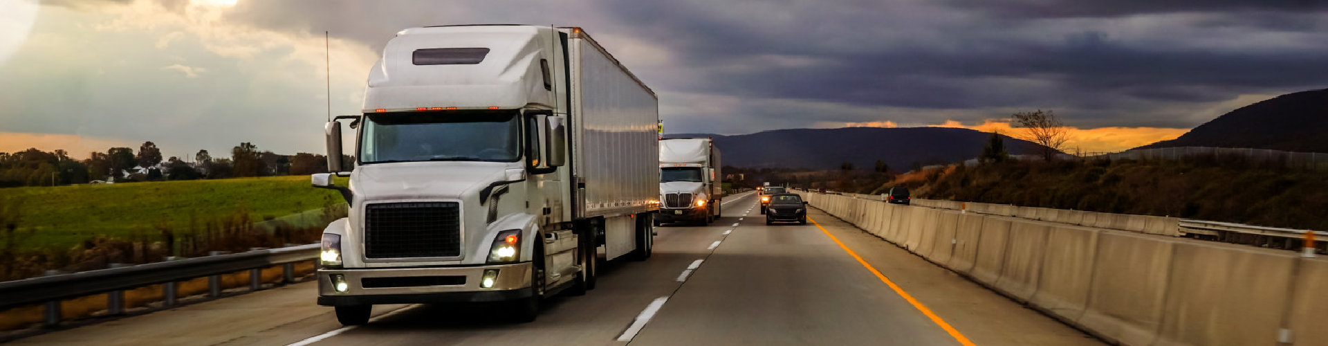 two trailer trucks in convoy in a vacant road